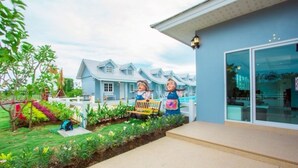Un immeuble résidentiel doté d’un jardin bien entretenu et d’un banc.