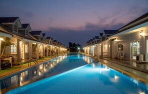 Una piscina con vista despejada al área de la piscina, que incluye sillones de descanso y un paseo techado.