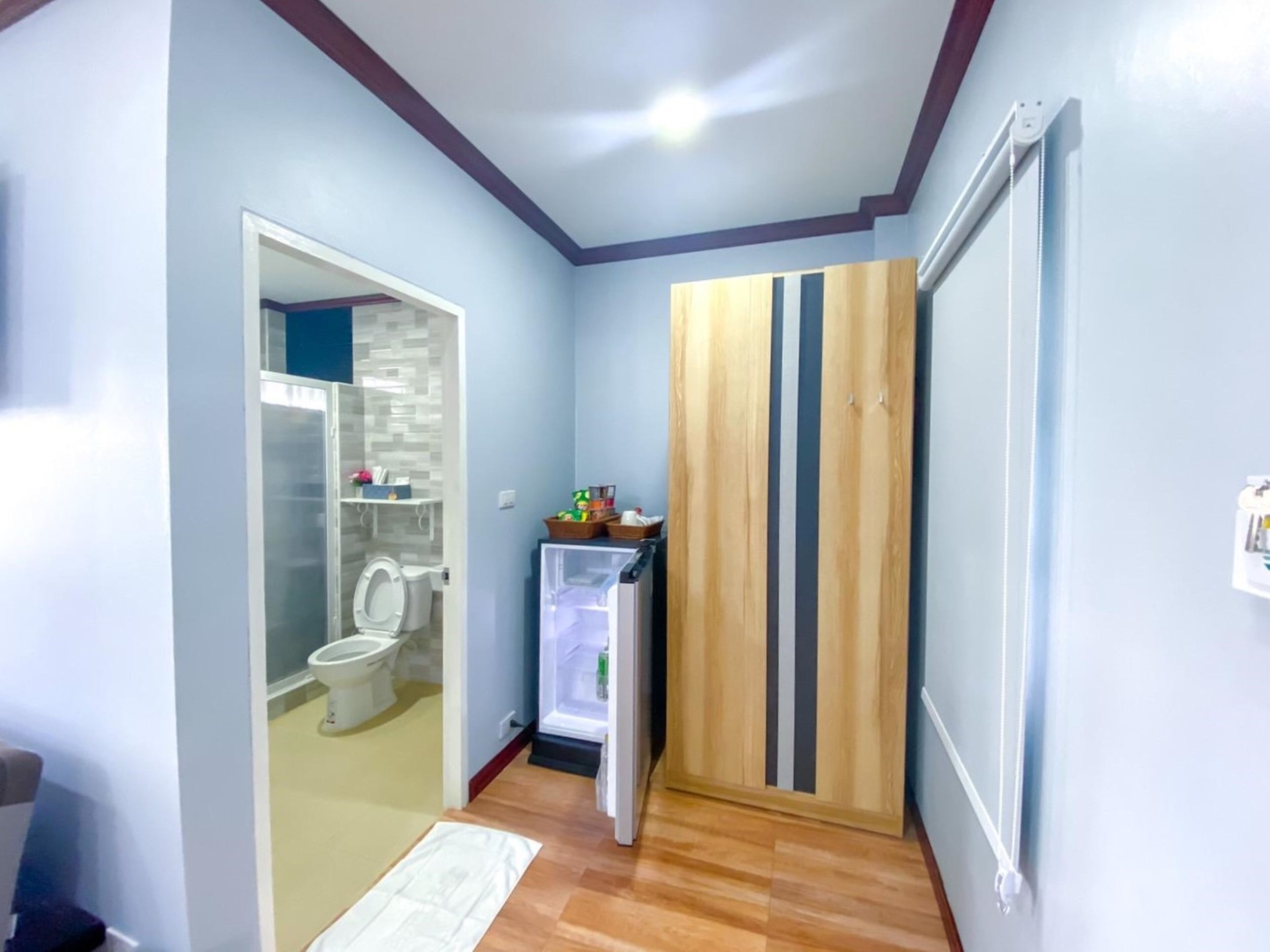A compact bathroom with a toilet, a small cabinet, and a glass shower enclosure.