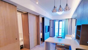 A modern hotel room with a marble floor, wooden wardrobe, a small kitchen area with a bar stool, and a large window with curtains. - fuan hotel (Shenzhen)