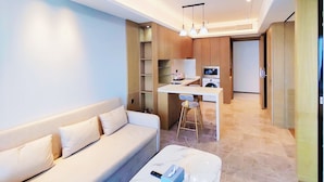 A modern living room with a sofa, a marble coffee table, and a kitchen area in the background. - fuan hotel (Shenzhen)