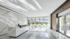 A modern reception area with marble flooring and a reception desk. - fuan hotel (Shenzhen)