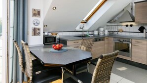 A modern kitchen with a dining area, featuring a large window, skylight, and contemporary appliances. - Müller (App. 11 ) by Interhome (Zinnowitz)