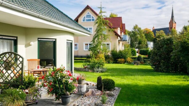 A residential area with houses, a lawn, and a church steeple in the background. - Schneider by Interhome (Zinnowitz)