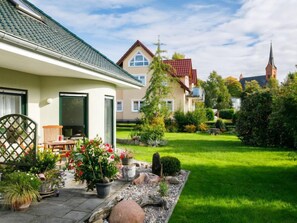 Et boligområde med huse, en græsplæne og et kirketårn i baggrunden.
