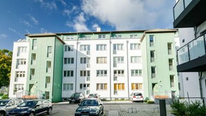 A multi-story residential building with a parking area in front. - Zur Düne I by Interhome (Zinnowitz)