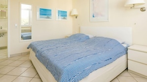 A bedroom with a bed, a nightstand, a window, and wall-mounted lamps. - Zur Düne I by Interhome (Zinnowitz)