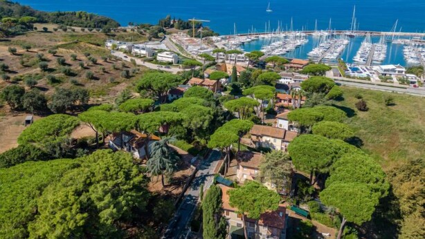 An aerial view of a coastal town with a marina, residential buildings, and lush greenery. - Il Giglio by Interhome (Scarlino)