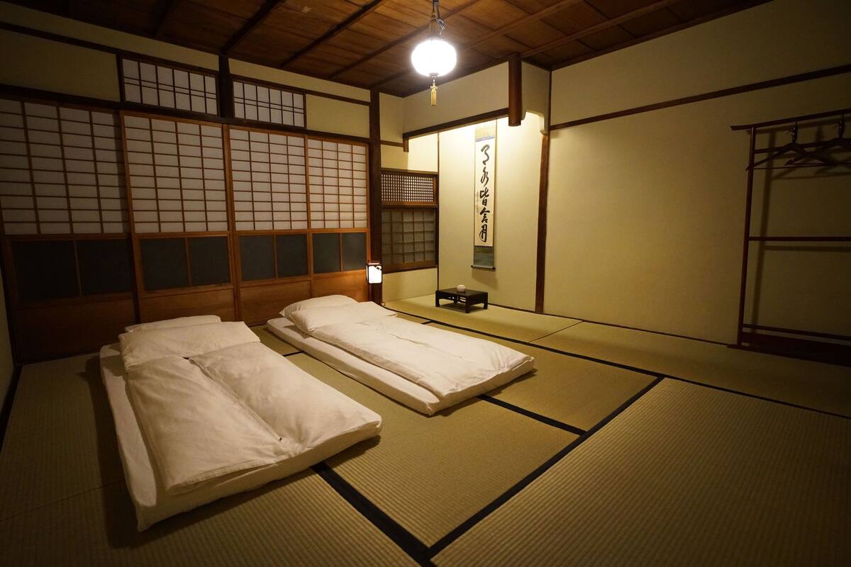 Een traditionele Japanse kamer met tatami vloeren, twee tatami matten, een lage tafel en een hangende kapstok.