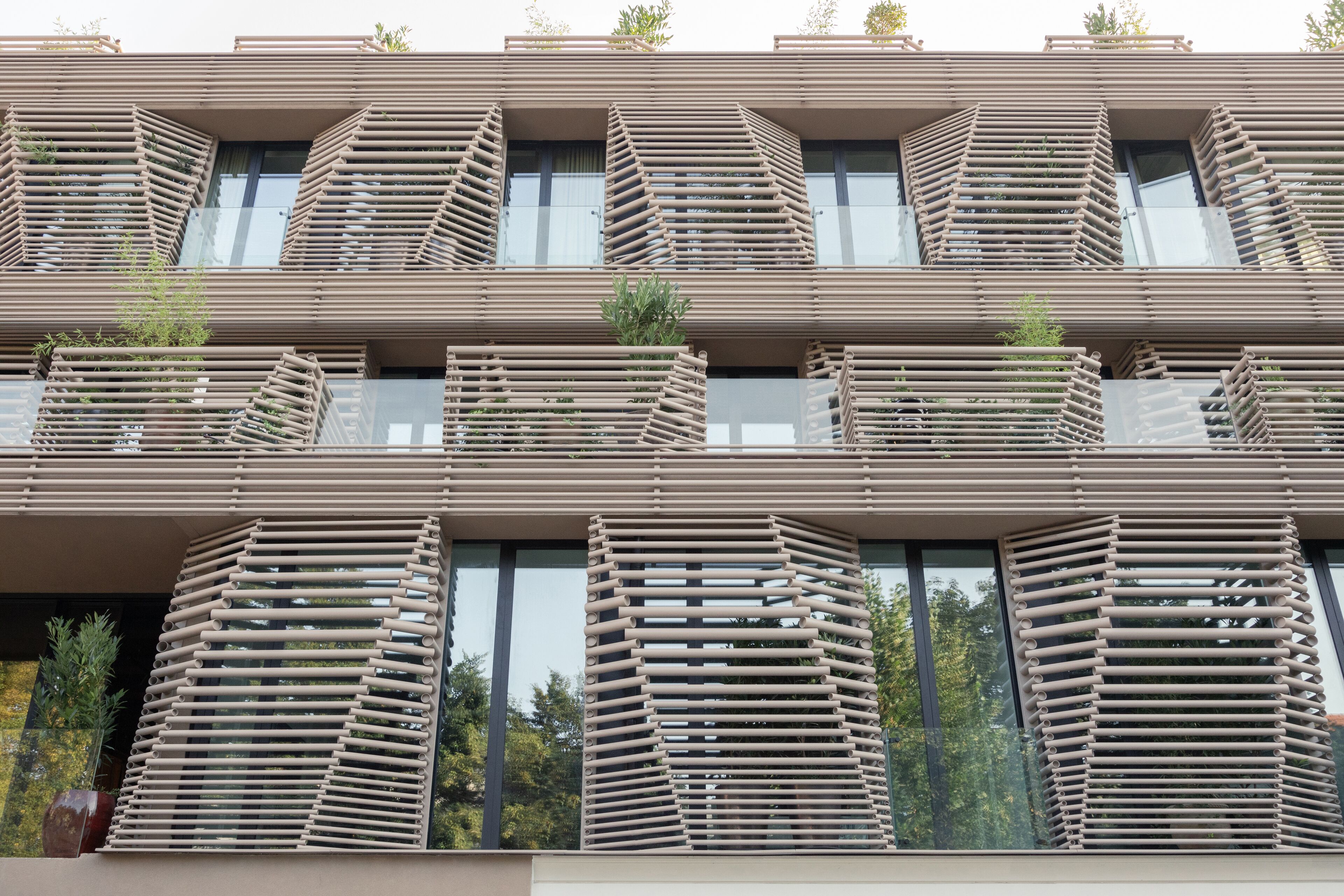 A modern building with multiple balconies, each with a unique geometric design.