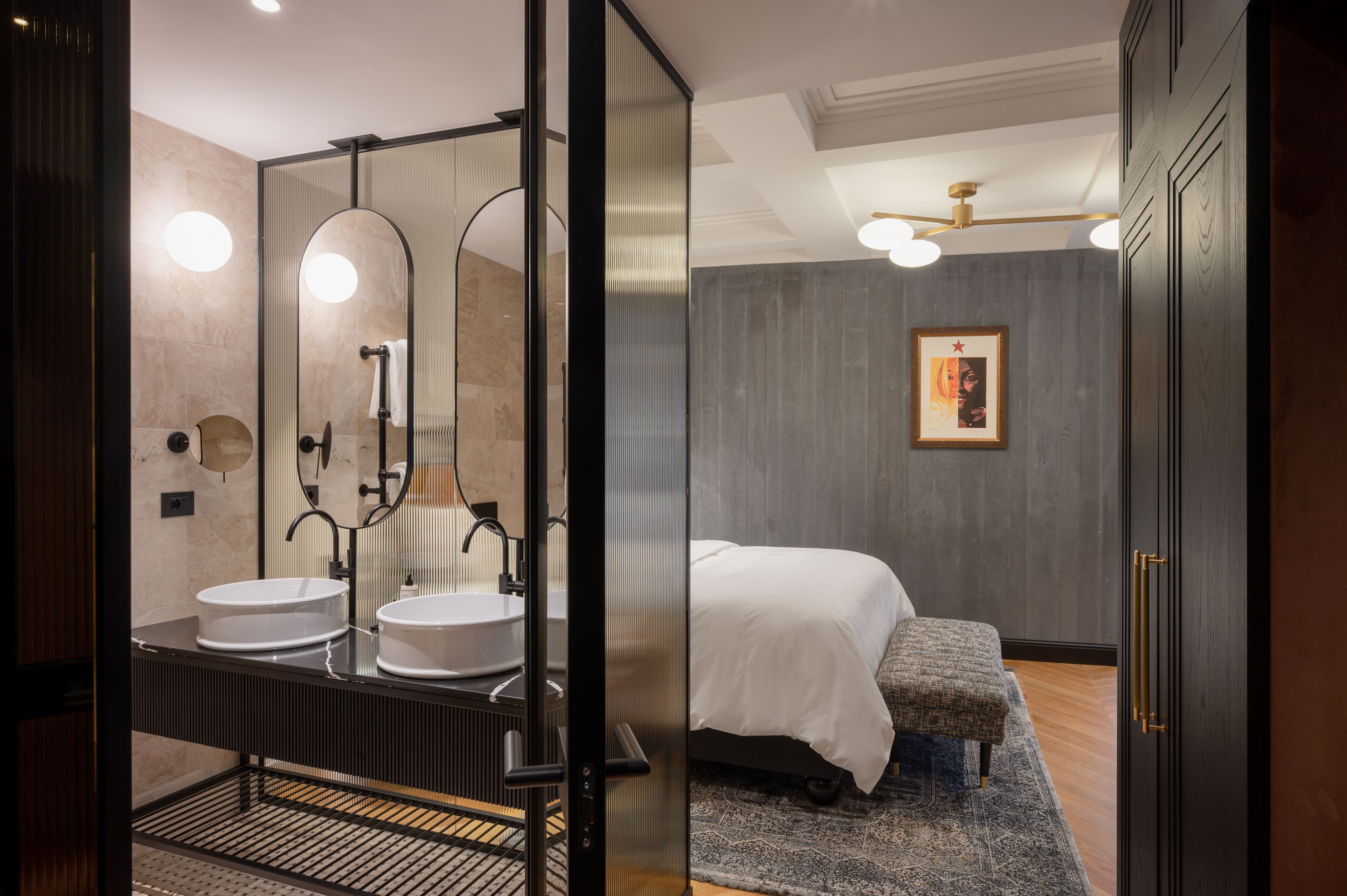 A modern bathroom with two sinks, a large mirror, and a walk-in shower.