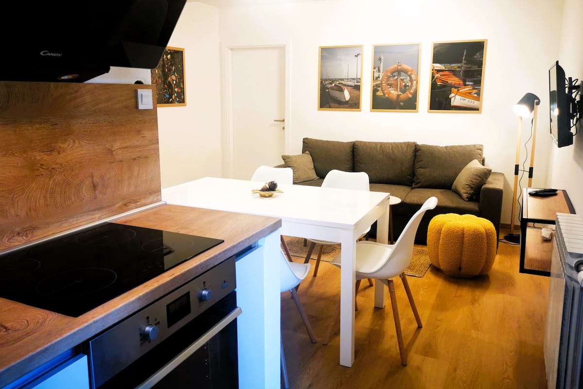 Un espace de vie compact comprenant un coin cuisine, un coin repas et un canapé.