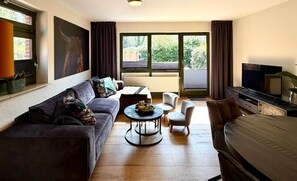 A modern living room with a sofa, a coffee table, and a TV.
