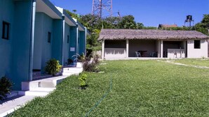 A building with a blue exterior and a thatched-roof structure. - Praia De Tofo (Tofo)