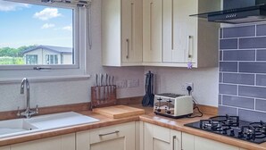 Une cuisine équipée d’un évier, d’un plan de travail, d’un grille-pain, d’une cuisinière et de placards.