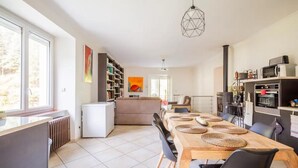 Una cocina moderna con comedor, ventanas amplias y vistas al exterior.