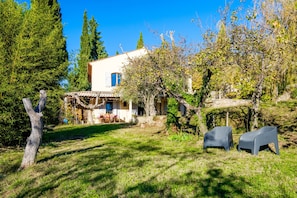 A house with a patio, a dining area, and two chairs in the yard. - Holiday Home 'Villa Provence Vue Panoramique -' with Mountain View, Private Pool and Wi-Fi (Fayence)