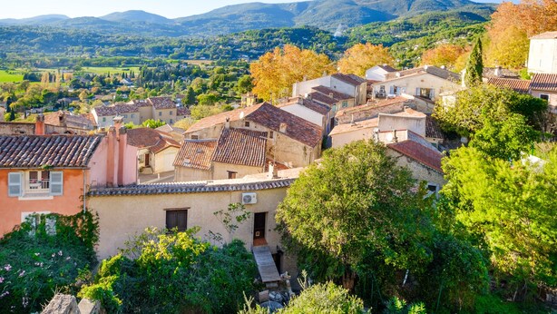 Un pueblo en la ladera con arquitectura tradicional, casas escalonadas y vistas al valle.
