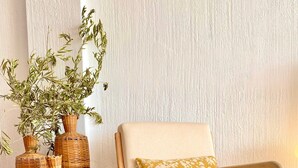 A room with a beige armchair, a patterned cushion, and three wicker vases with green plants. - 'Sea Views Nice Sunset Sun' Apartment with Sea View, Shared Pool, and Wi-Fi (Nerja)