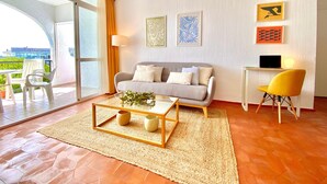 A modern living room with a sofa, coffee table, and artwork on the wall. - 'Sea Views Nice Sunset Sun' Apartment with Sea View, Shared Pool, and Wi-Fi (Nerja)