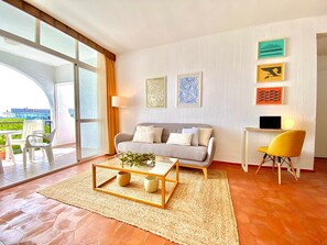 Un salon moderne avec un canapé, une table basse et des œuvres d’art accrochées au mur.