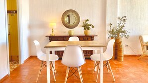 A dining area with a wooden table, white chairs, a lamp, a mirror, and a potted plant. - 'Sea Views Nice Sunset Sun' Apartment with Sea View, Shared Pool, and Wi-Fi (Nerja)