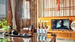A traditional room with a wooden interior, a television, and a table with bottles.
