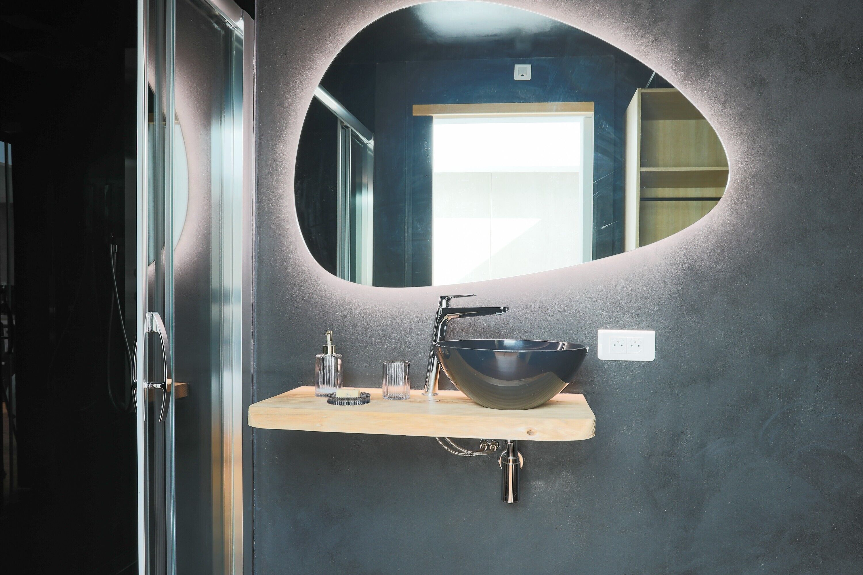 Une salle de bain avec un lavabo moderne, un miroir et une douche.