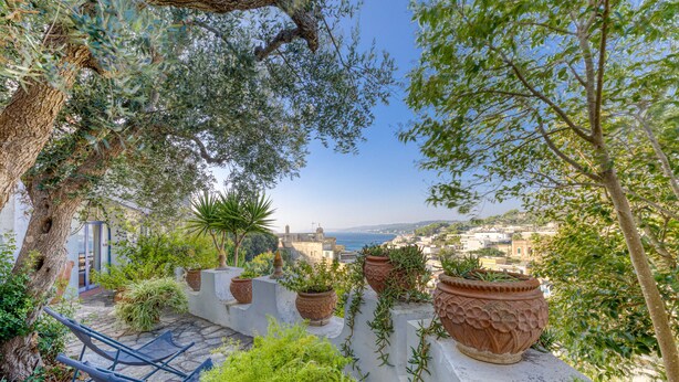 A rooftop garden with potted plants, a blue chair, and a view of the city and sea. - Villa 'Blu La Cambusa' with Shared Pool, Wi-Fi and Air Conditioning (Castro)