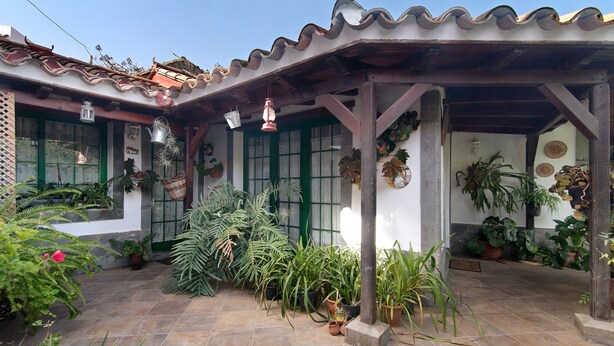 A covered patio with potted plants and a tiled floor. - Holiday Home "El Llanete" with Mountain Views, Shared Pool & Wi-Fi (Vega de San Mateo)