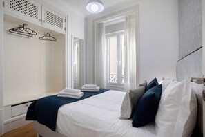 A bedroom with a bed, a wardrobe, a window, and a balcony. - Apartment "Casa Ribeiro - Escandinavo" with Balcony & Wi-Fi (Nazaré)