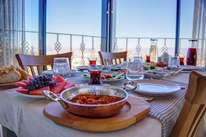 Enjoy a meal with scenic views on this outdoor dining area, complete with a table set for several people.