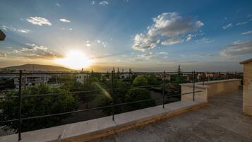 Un balcón con vista a un paisaje urbano al atardecer.