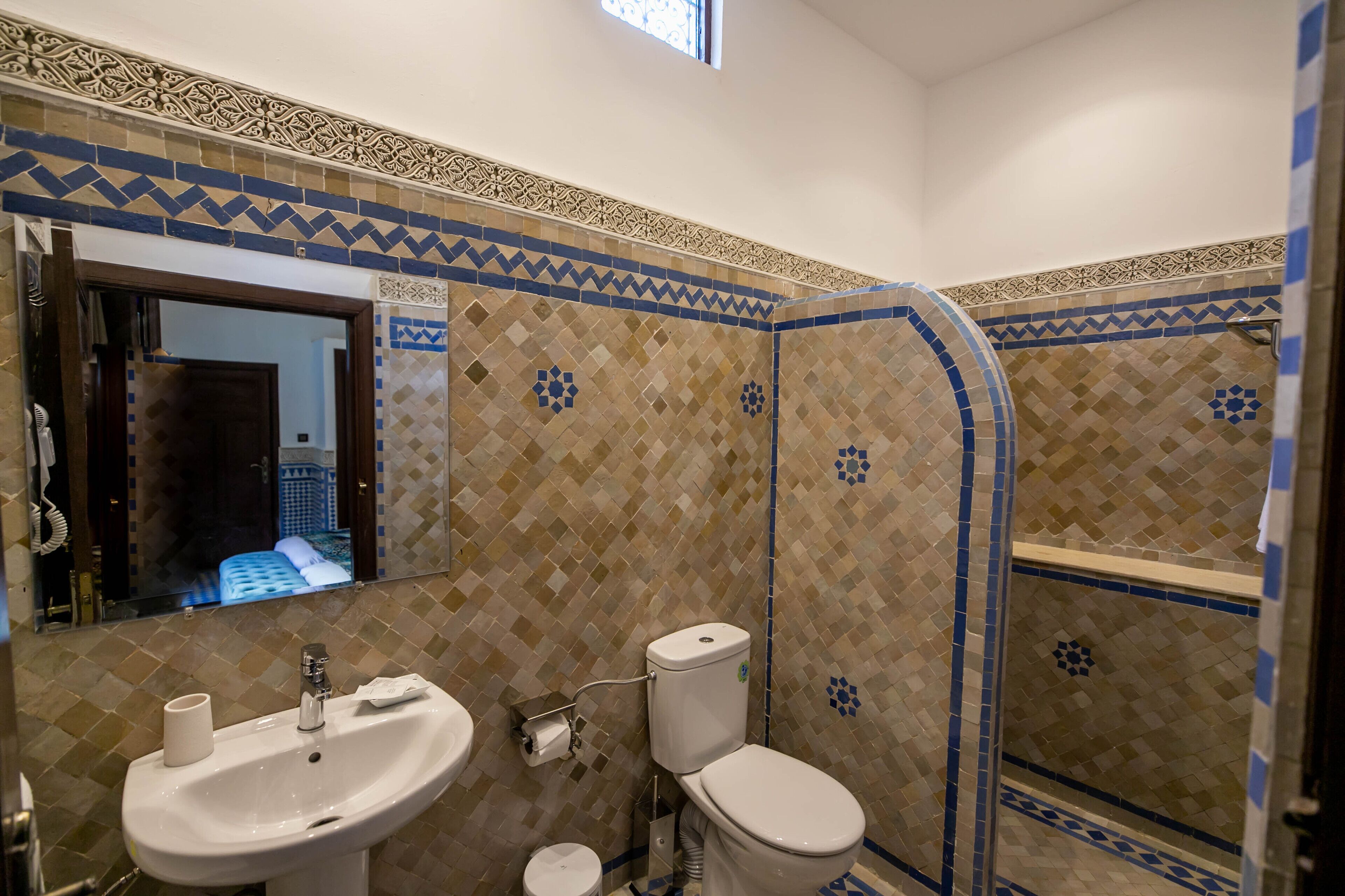 A bathroom with a sink, toilet, and shower.