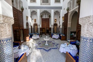 A traditional Moroccan interior with ornate tile work, wooden doors, and a central fountain. - Riad Fes Ziyat & Spa (Fes)