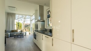 A modern kitchen with white cabinets, a black countertop, and a large window.