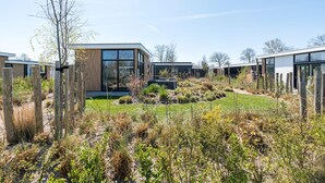 Un quartier résidentiel moderne comprenant plusieurs maisons, une pelouse verdoyante et un ciel dégagé.