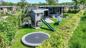 A residential area with modern houses, a playground, and a trampoline.