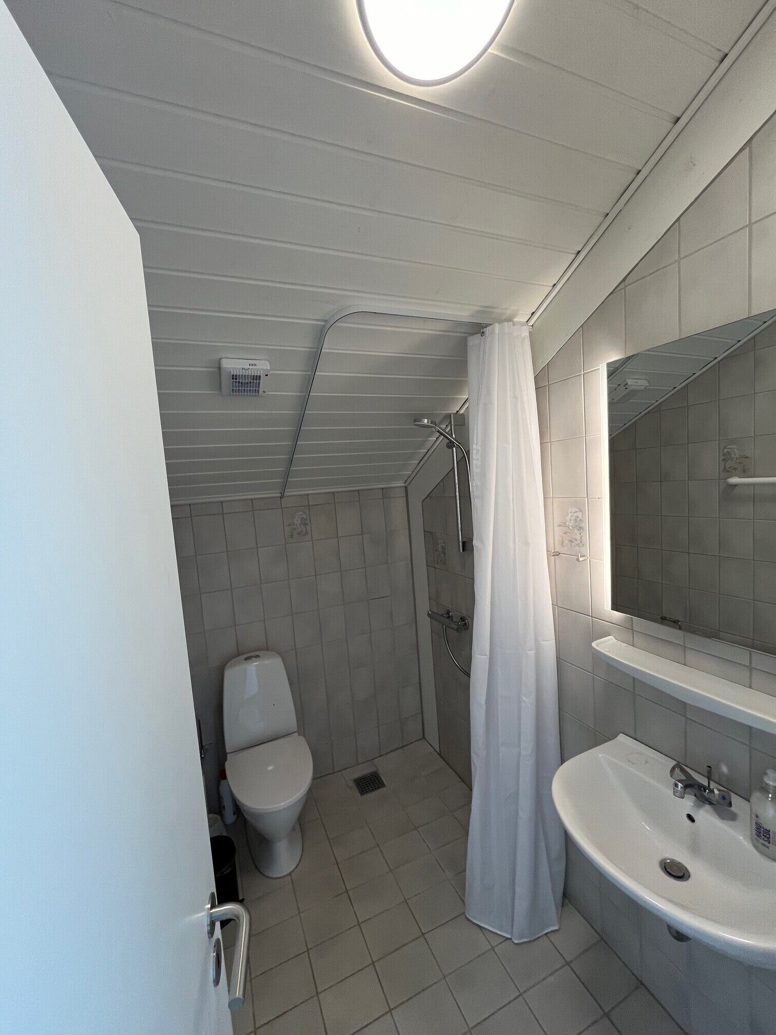 Un baño con inodoro, ducha y lavamanos.