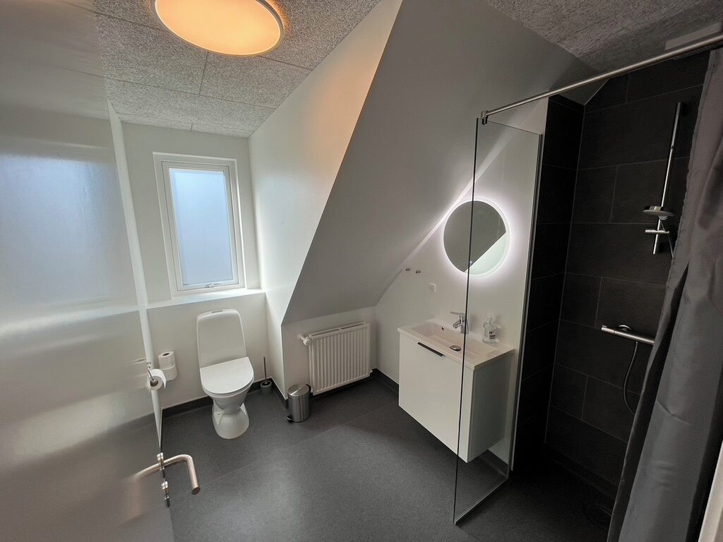 Une salle de bain moderne équipée de toilettes, d’un lavabo et d’une douche.