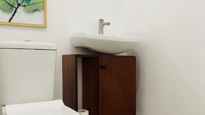 Ein Badezimmer mit Toilette, Waschbecken und Spiegel.
