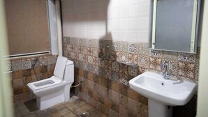 A bathroom with a toilet, sink, and shower. - Home Stay Green View Doon (Dehradun)