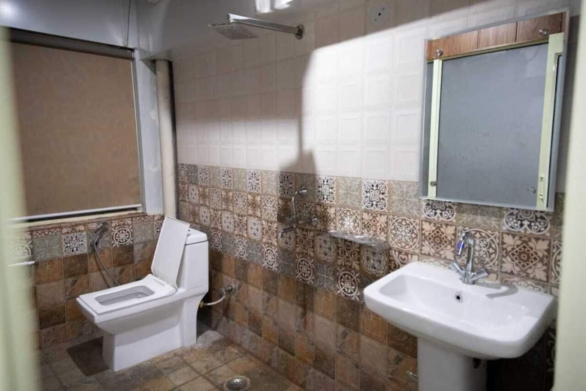 A bathroom with a toilet, sink, and shower.