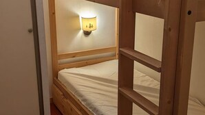 Ein Stockbett mit Kopfstütze und einer Wandleuchte.