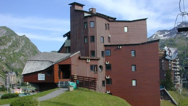 A modern building with a unique architectural design, featuring a sloped roof and multiple windows.