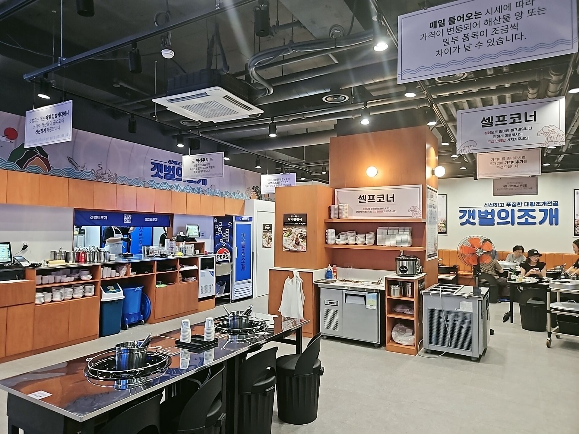 A restaurant with a counter, seating area, and various food items displayed on shelves.