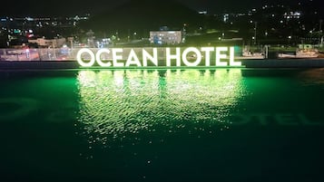 El letrero del Hotel Ocean reflejado en el agua, con un paisaje urbano de fondo.