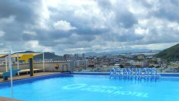 Piscina com paisagem urbana ao fundo e o texto "MOKPO OCEAN HOTEL" visível.