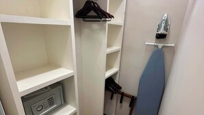 A walk-in closet with open shelving, a hanging rack, and a built-in ironing board. - Arquimedes Deco - Colourful 1BR in Polanco (Mexico City)