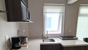Eine moderne Küche mit Backofen, Kaffeemaschine, Toaster und Spüle.